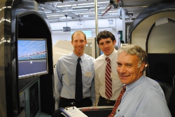 photograph - Man in a flight simulator, two others look on